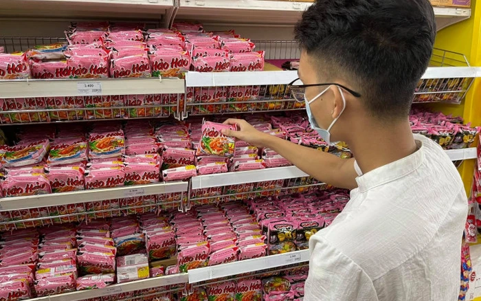 Hình ảnh các sản phẩm mì ăn liền của Acecook được trưng bày tại một gian hàng siêu thị. Các gói mì Hảo Hảo, Gấu Đỏ và nhiều sản phẩm khác được bày trí gọn gàng, thu hút sự chú ý của người tiêu dùng